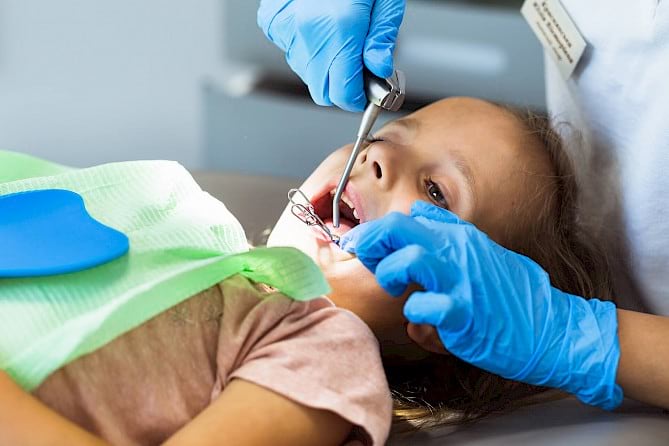 Child on dentist chair undergoing treatment.