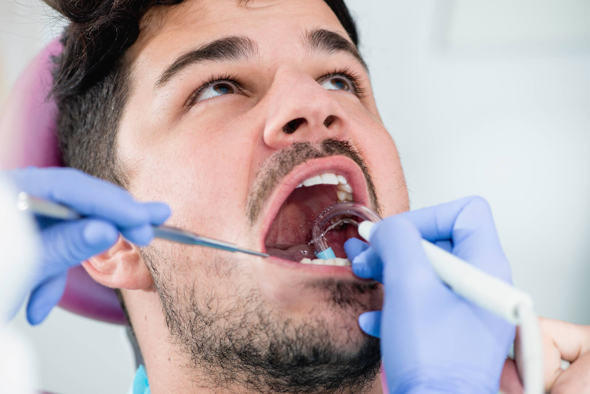 Man undergoing professional teeth cleaning.