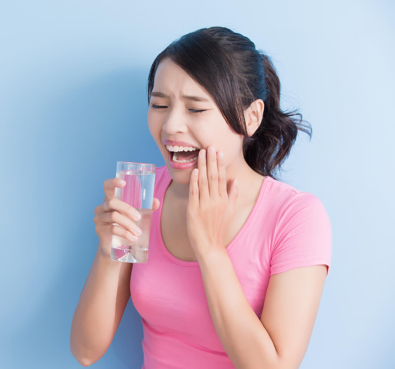 Woman with sensitive teeth when drinking cold water.