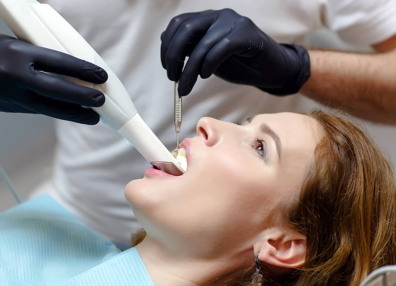 Woman in dental checkup with a dental scanner.