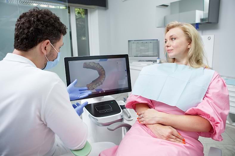 Dentist explaining the result of dental scanner to patient.