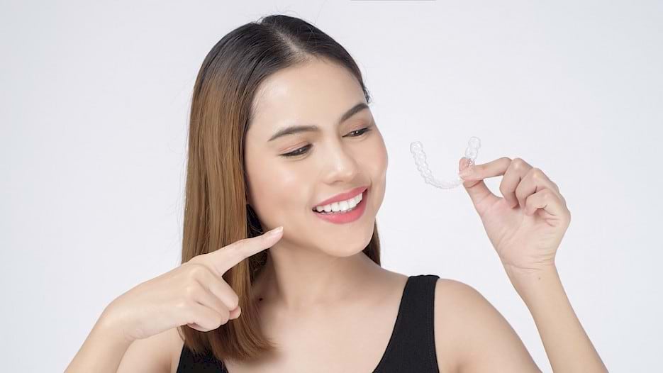 Woman holding clear aligners.